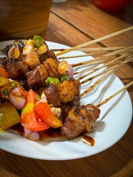 skewered beef meat on a grill, or barbecue bbq, locals called it beef satay showcasing their vibrant glaze and texture. Perfect representation of barbecue culture, grilling cuisine, and outdoor cooking enjoyment.