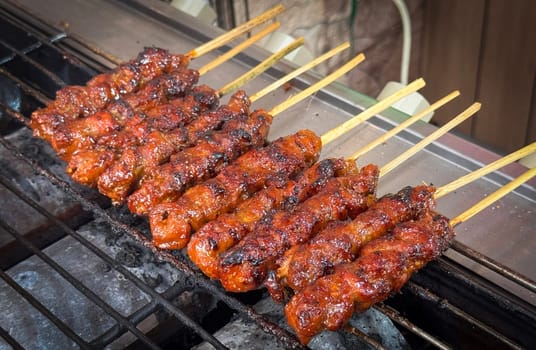 skewered beef meat on a grill, or barbecue bbq, locals called it beef satay showcasing their vibrant glaze and texture. Perfect representation of barbecue culture, grilling cuisine, and outdoor cooking enjoyment.