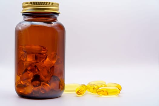 Amber glass bottle containing Omega-3 softgel capsules, with additional capsules scattered on a white background for a clean and minimal look.
