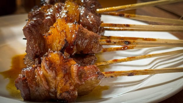 skewered beef meat on a grill, or barbecue bbq, locals called it beef satay showcasing their vibrant glaze and texture. Perfect representation of barbecue culture, grilling cuisine, and outdoor cooking enjoyment.