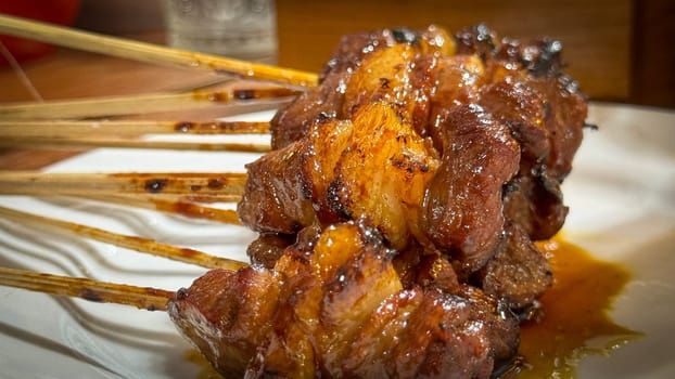 skewered beef meat on a grill, or barbecue bbq, locals called it beef satay showcasing their vibrant glaze and texture. Perfect representation of barbecue culture, grilling cuisine, and outdoor cooking enjoyment.