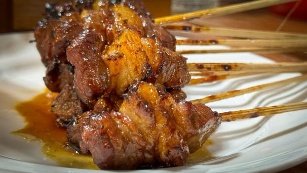 skewered beef meat on a grill, or barbecue bbq, locals called it beef satay showcasing their vibrant glaze and texture. Perfect representation of barbecue culture, grilling cuisine, and outdoor cooking enjoyment.