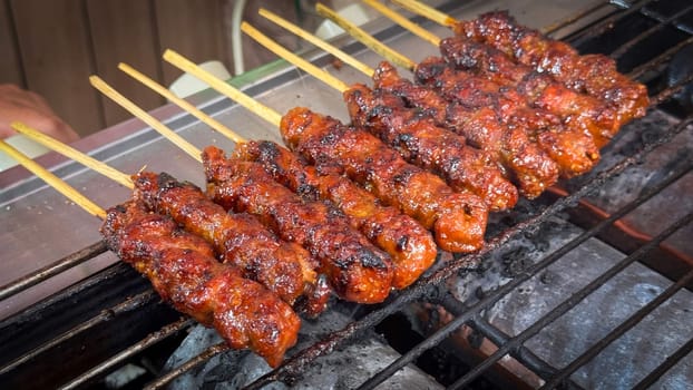 skewered beef meat on a grill, or barbecue bbq, locals called it beef satay showcasing their vibrant glaze and texture. Perfect representation of barbecue culture, grilling cuisine, and outdoor cooking enjoyment.