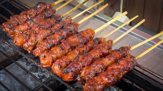 skewered beef meat on a grill, or barbecue bbq, locals called it beef satay showcasing their vibrant glaze and texture. Perfect representation of barbecue culture, grilling cuisine, and outdoor cooking enjoyment.