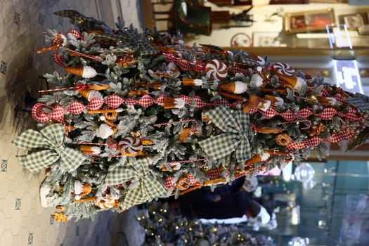 A beautiful and vibrant Christmas tree is adorned with colorful, candyinspired decorations and festive ribbons