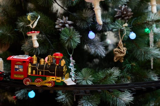 A charming toy train decorates a vibrant Christmas tree adorned with colorful ornaments and sparkling lights