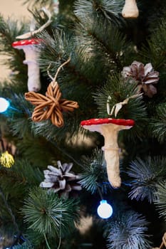 A decorative Christmas tree with charming wooden ornaments, vibrant mushrooms, and lovely natural elements