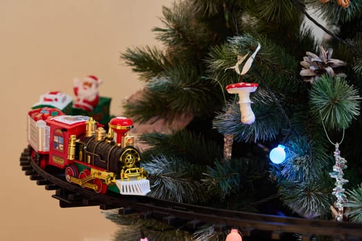 A charming train set gracefully circles a beautifully decorated Christmas tree adorned with festive lights