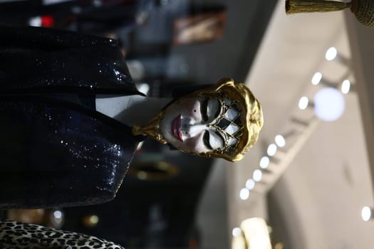 A chic mannequin beautifully displaying a glamorous outfit and striking mask in contemporary fashion