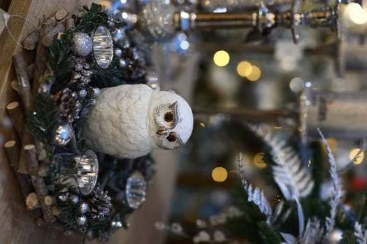 A charming winter decoration featuring a beautiful white owl nestled comfortably in a festive holiday wreath