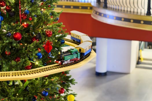 A cheerful train set thoughtfully adorning a beautifully designed Christmas tree with festive decorations