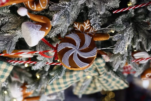 Brightly colored candy and charming gingerbread ornaments beautifully adorning a festive Christmas tree this season