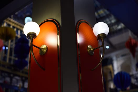 In a modern setting, stylish wallmounted lights are artistically arranged on vibrant red panels, creating ambiance