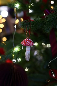 A vibrant red mushroom ornament adds a charming festive touch to your Christmas tree this holiday season