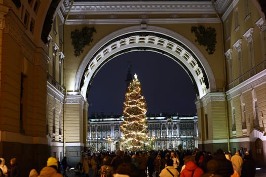 A beautifully festive scene showcasing a brightly lit Christmas tree nestled among a bustling crowd in a lovely archway