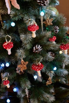 A beautifully decorated Christmas tree featuring charming red mushroom ornaments and twinkling lights.