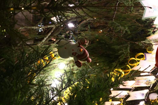 A charming Christmas tree beautifully adorned with a playful snowman ornament surrounded by vibrant greenery