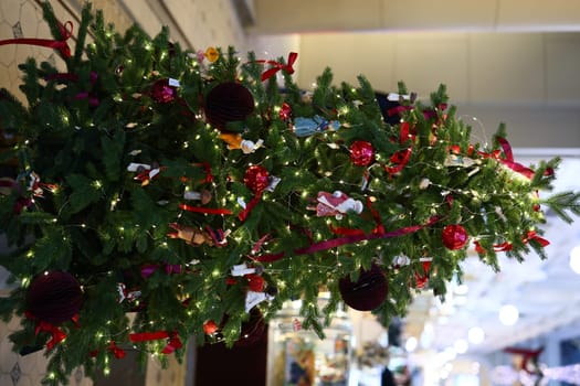A beautifully adorned Christmas tree featuring vibrant lights and colorful ornaments set in a sophisticated space