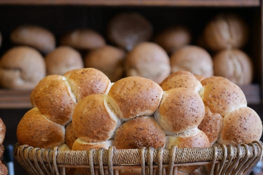 Delicious, beautifully golden brown bread rolls are artistically displayed in a woven basket