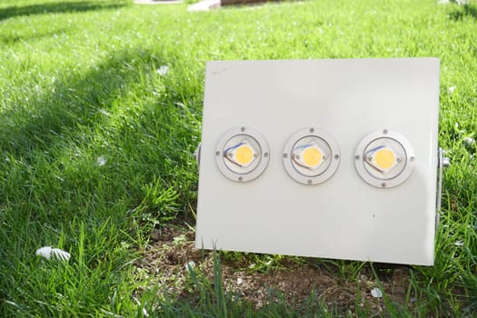 A contemporary outdoor lighting fixture has been installed on a vibrant, lush green grass area