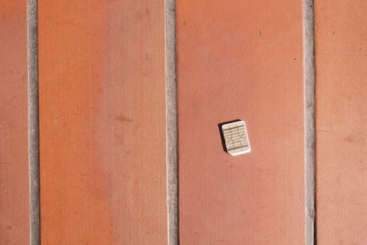 a phone sim card dropped on a tiles floor. lost sim card concept ,