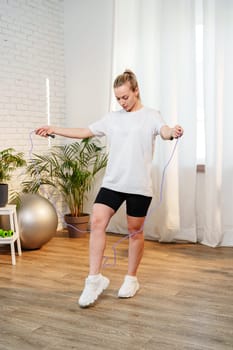 A woman skipping rope in a bright living room filled with plants close up