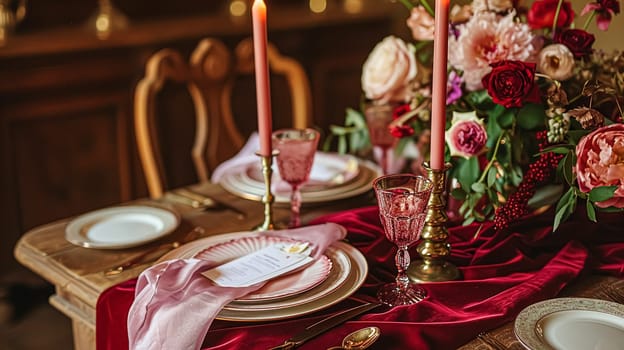 Festive table setting with candles and arrangement of beautiful red flowers. Holiday concept. High quality photo