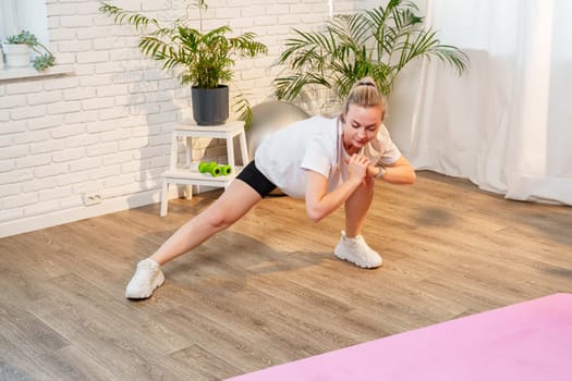 Woman performing a stretching exercise in a bright indoor fitness space