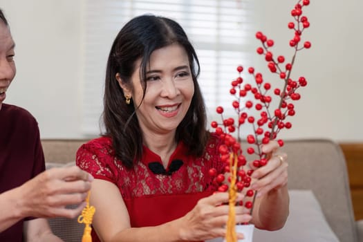 An elderly couple joyfully prepares decorations for the Chinese New Year at home embracing tradition and togetherness.