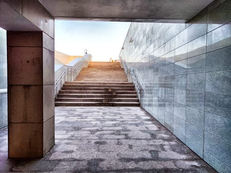Sturdy granite stairs ascend toward clear sky, illuminated by the morning light