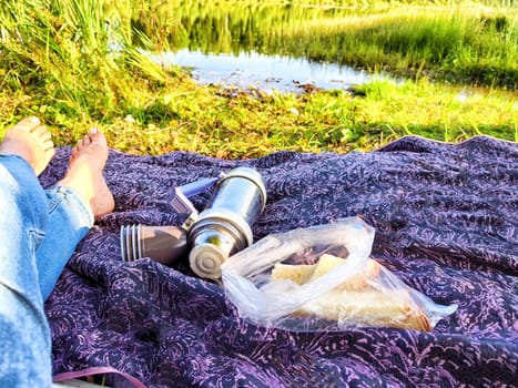 Enjoying a peaceful afternoon at the lakeside, savoring food and drinks while surrounded by lush greenery.