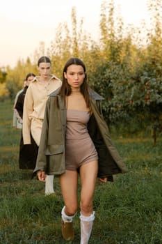 A group of stylish girls in stylish clothes at a fashion show in the garden.