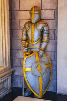 statue of medieval European knight in armor with a sword and shield in castle