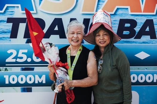 Sea Star competitions. The awarding of an elderly Asian woman, a participant in a swimming competition, takes place on the beach of Nha Trang. Nha Trang, Vietnam - July 25, 2024.