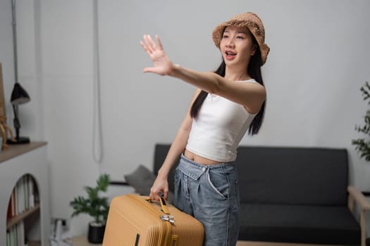 A young woman enthusiastically packs her suitcase, preparing for an exciting travel adventure from her modern home.