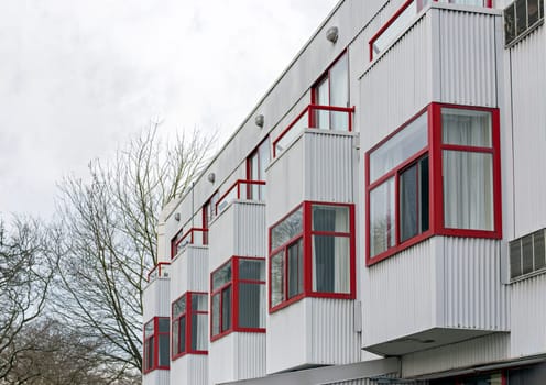Goffer wall of residential building with erker windows in the row on overcast sky background