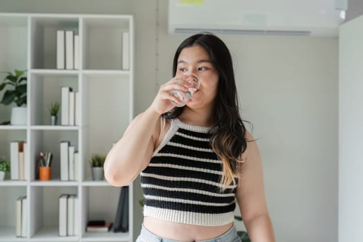 A young woman embraces a healthy lifestyle by enjoying nutritious food in a cozy home setting.