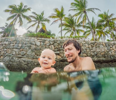 Toddler and father joyfully swimming in the turquoise Caribbean Sea. Family bonding, seaside fun, and tropical vacation concept.