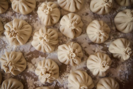 Traditional Georgian khinkali dumplings handmade in a kitchen, showcasing the intricate folding details.
