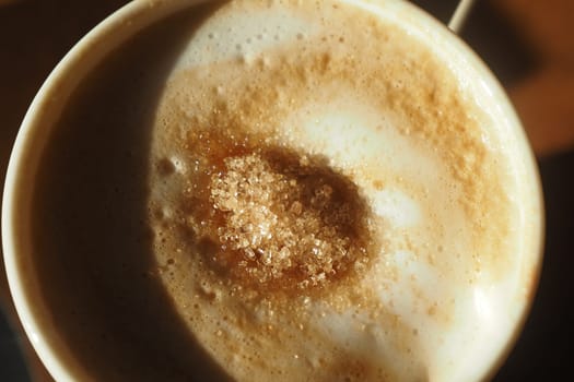 brown sugar pouring from a in a paper packet on a coffee cup ,