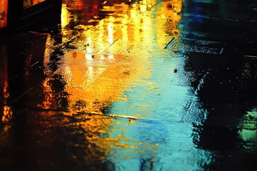 Capture the essence of a rainy night in the city with vibrant reflections on slick pavement, showcasing a stunning array of colors and lights.
