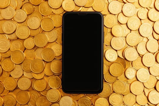 A sleek smartphone with a blank screen rests atop a vibrant pile of shiny gold coins. This image symbolizes wealth, investment, and digital technology.