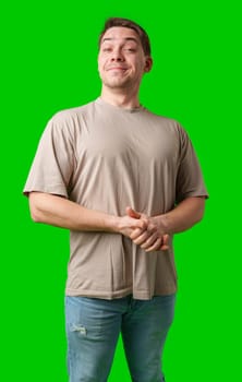 A cheerful man with a friendly smile poses against a bright green background in studio