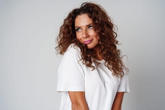 Young woman posing confidently in casual attire against a neutral backdrop close up