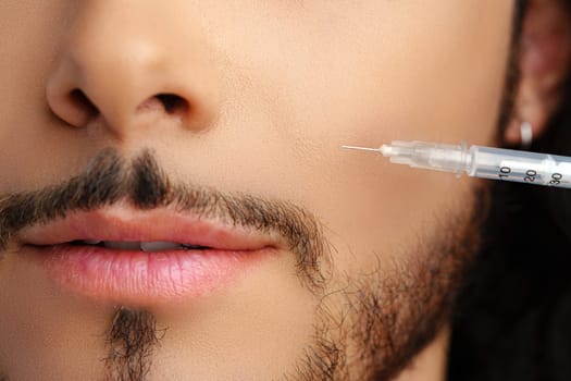 Man receiving facial treatment with a syringe for enhancing appearance, likely in a modern clinic