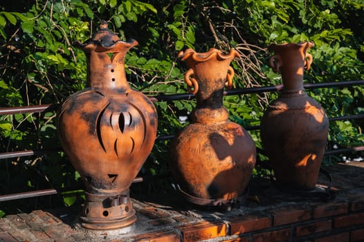 Vintage clay jugs and vases decorate the Asian garden in summer