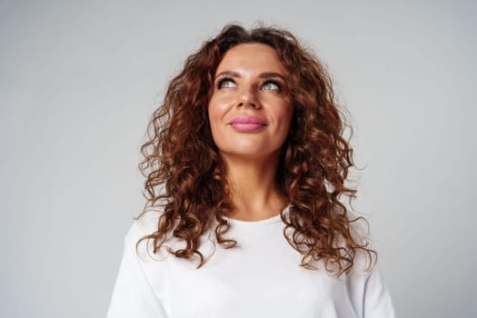 Young woman posing confidently in casual attire against a neutral backdrop close up