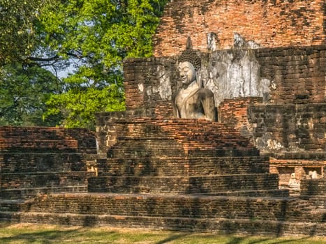 Buddha statue at Wat Mahathat Maha That temple by day, Sukhothai, Thailand