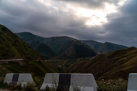 The mountains are covered in green grass and the sky is cloudy