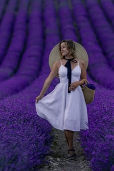 A woman in a white dress stands in a field of purple flowers. She is holding a basket and wearing a straw hat. The scene is serene and peaceful, with the woman enjoying the beauty of the flowers